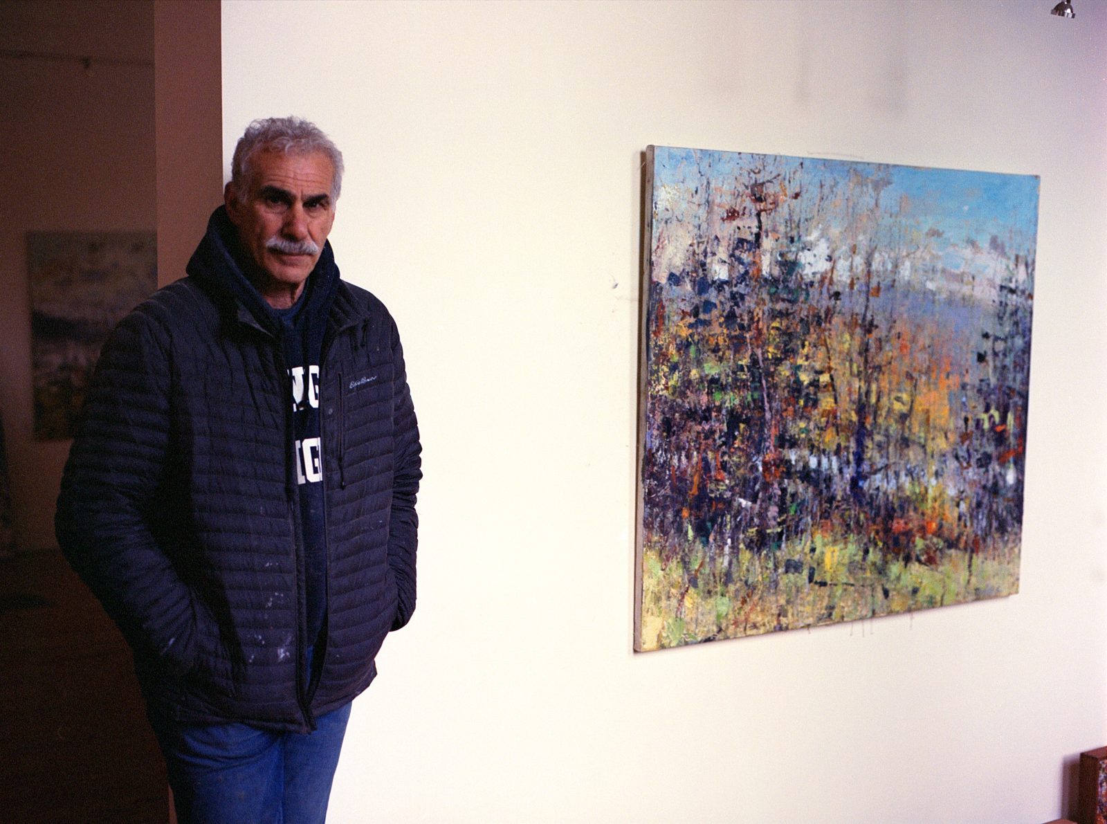 Mr. Chickillo stands next to one of his large oil paintings