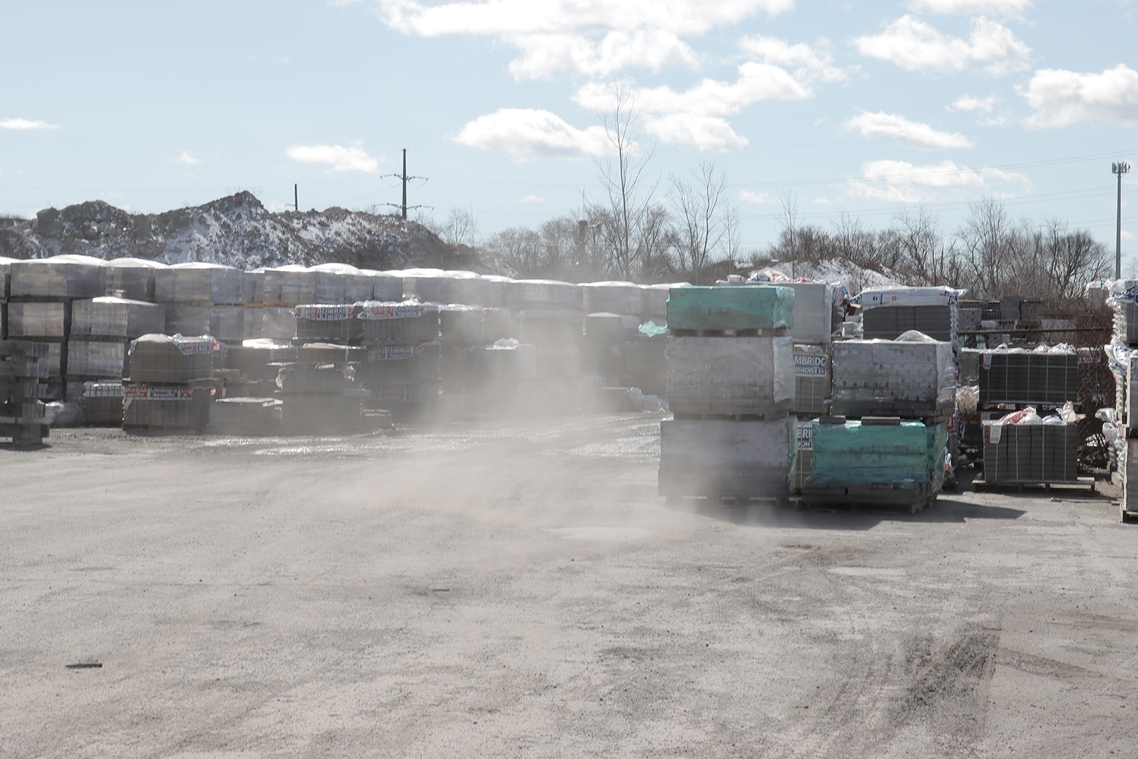 Wind stirs the dust in the parking lot of a concrete supply company