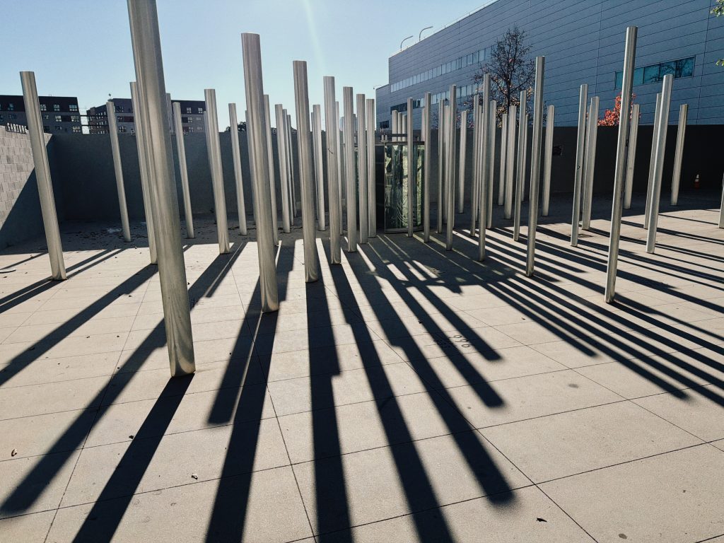 An art installation of poles casting shadows.